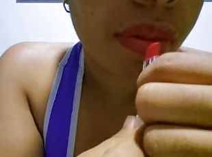 Ebony girl with full lips seduces you while applying lipstick